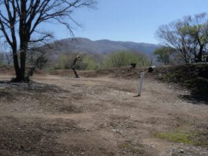 玄蕃尾城の郭。周囲を土塁が囲み、奥に山並みが広がる