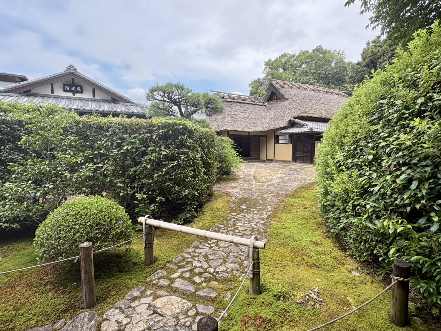 慈光院の書院と茅葺屋根の建物、手前は苔の庭と石畳