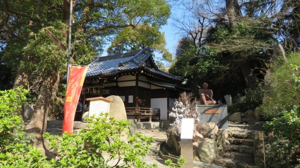 安居神社の本殿と、座り込む姿の真田幸村像